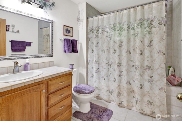 bathroom featuring a shower with shower curtain, toilet, vanity, and tile patterned flooring