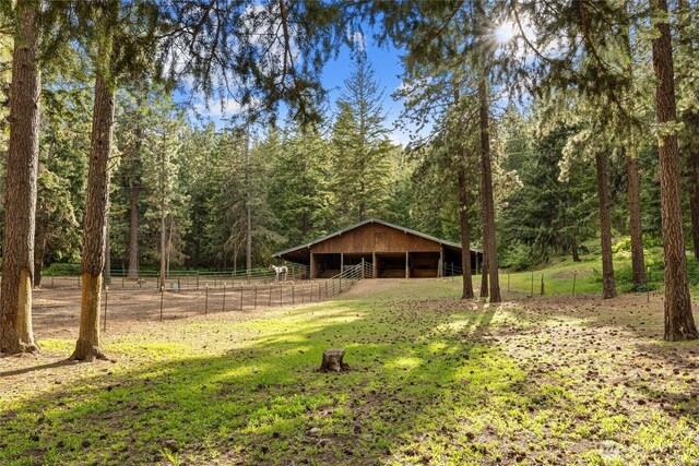 1101 Emerick Rd, Cle Elum, WA 98922 - view of yard featuring an exterior structure, a forest view, and an outdoor structure