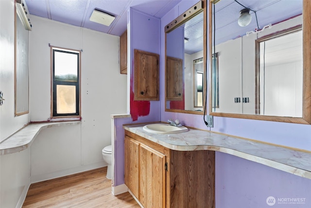 15016 W Thorne Ln SW Unit 7, Lakewood, WA 98498 - bathroom with toilet, wood finished floors, vanity, and baseboards