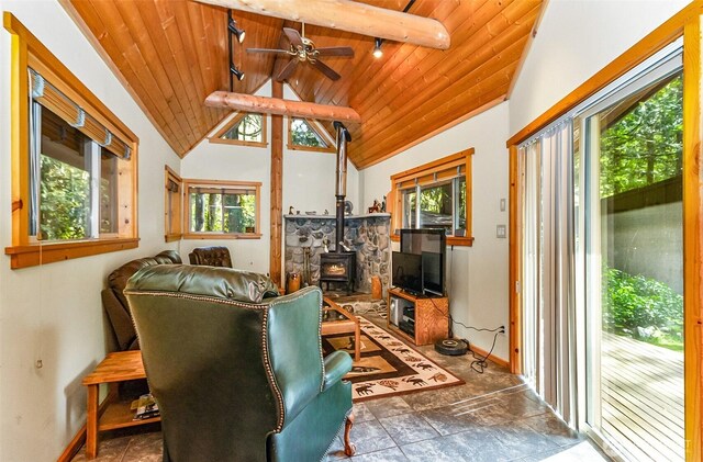 18242 643rd Ave NE Unit 54, 53, Baring, WA 98224 - living room featuring healthy amount of natural light, wood ceiling, a wood stove, ceiling fan, and baseboards