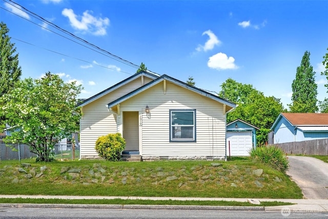 1319 E 56th St, Tacoma, WA 98404 - view of front of property featuring driveway, fence, a detached garage, and an outbuilding