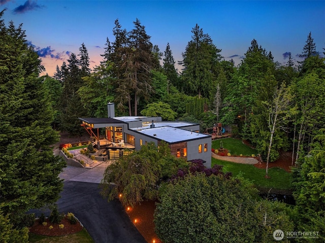 aerial view of property and surrounding area with a heavily wooded area