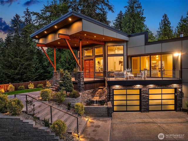 view of front of property featuring stairway, a garage, and concrete driveway