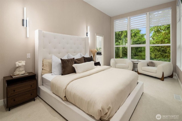 bedroom featuring light carpet and baseboards