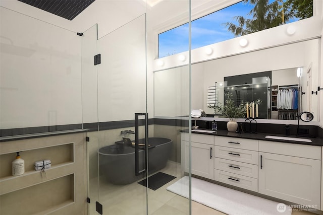 bathroom with a stall shower, double vanity, tile patterned floors, and a soaking tub