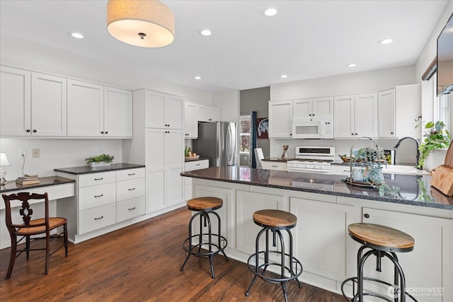 1438 NW 202nd Ln, Shoreline, WA 98177 - kitchen featuring white appliances, a peninsula, white cabinetry, dark wood-style flooring, and recessed lighting
