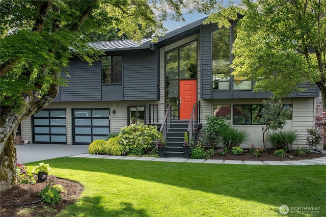 view of front of property featuring a standing seam roof, an attached garage, a front yard, and metal roof