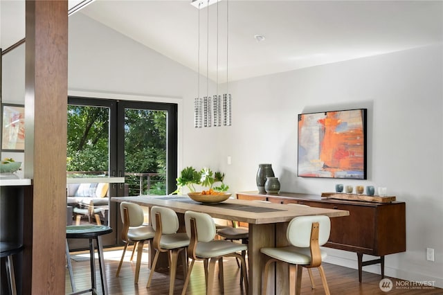 dining space with wood finished floors and vaulted ceiling