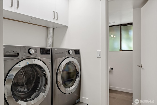 laundry room featuring cabinet space, washer and dryer, and baseboards