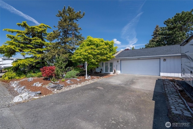 5418 Nootka Loop, Blaine, WA 98230 - view of property hidden behind natural elements with concrete driveway, french doors, a garage, and board and batten siding