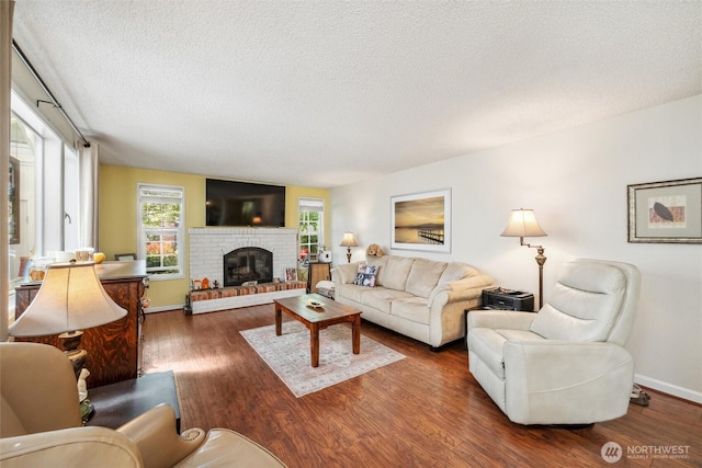 5418 Nootka Loop, Blaine, WA 98230 - living room with a textured ceiling, wood finished floors, a brick fireplace, and baseboards