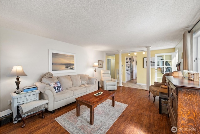 5418 Nootka Loop, Blaine, WA 98230 - living room featuring decorative columns, a textured ceiling, wood finished floors, baseboards, and rail lighting