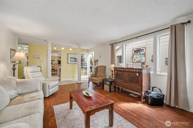 5418 Nootka Loop, Blaine, WA 98230 - living room featuring wood finished floors, decorative columns, a textured ceiling, and rail lighting