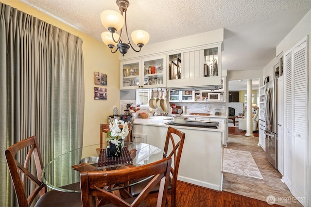 5418 Nootka Loop, Blaine, WA 98230 - dining space with a textured ceiling, wood finished floors, and a chandelier