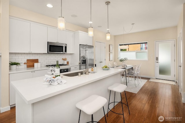 kitchen featuring stainless steel appliances, white cabinetry, decorative backsplash, and recessed lighting