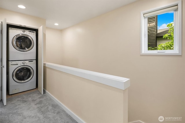 laundry area with stacked washer and clothes dryer, carpet floors, baseboards, and recessed lighting