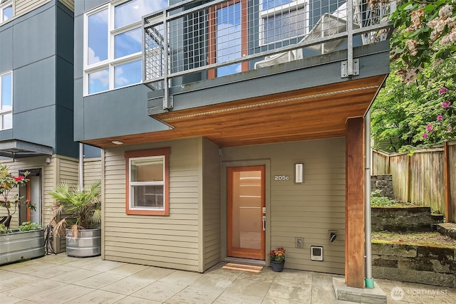 doorway to property featuring fence and a patio