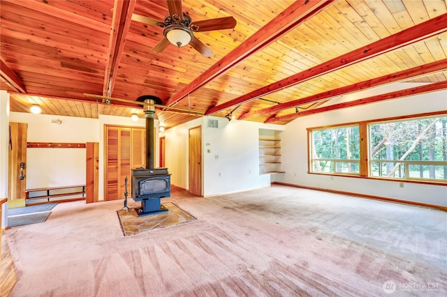 37611 Hansville Rd NE, Hansville, WA 98340 - unfurnished living room with wooden ceiling with exposed beams, a wood stove, carpet floors, baseboards, and ceiling fan
