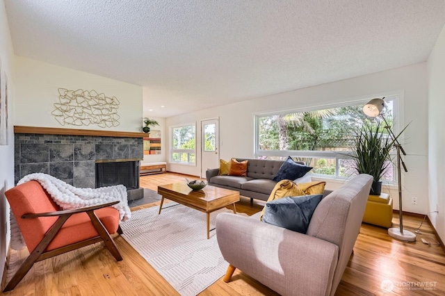 2545 NE 204th St, Shoreline, WA 98155 - living area featuring wood finished floors, a fireplace, a textured ceiling, and baseboards