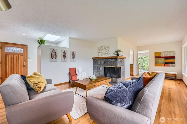 2545 NE 204th St, Shoreline, WA 98155 - living room with a skylight, light wood-type flooring, a fireplace, recessed lighting, and a textured ceiling