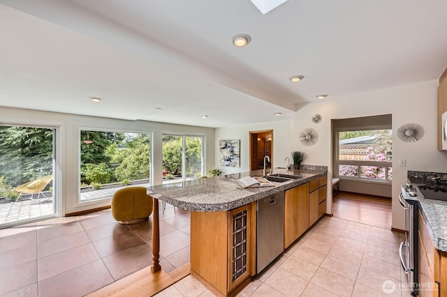 2545 NE 204th St, Shoreline, WA 98155 - kitchen with stainless steel appliances, tile countertops, a sink, brown cabinetry, and recessed lighting