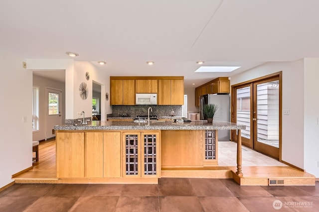 2545 NE 204th St, Shoreline, WA 98155 - kitchen featuring white microwave, freestanding refrigerator, backsplash, baseboards, and recessed lighting