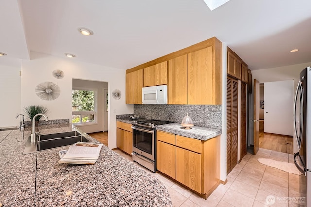 2545 NE 204th St, Shoreline, WA 98155 - kitchen featuring stainless steel appliances, a sink, decorative backsplash, light tile patterned flooring, and a skylight