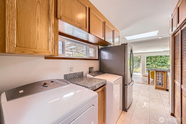2545 NE 204th St, Shoreline, WA 98155 - laundry room featuring a skylight, cabinet space, light tile patterned floors, and washer and clothes dryer