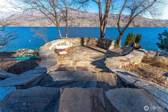 view of patio featuring a water and mountain view