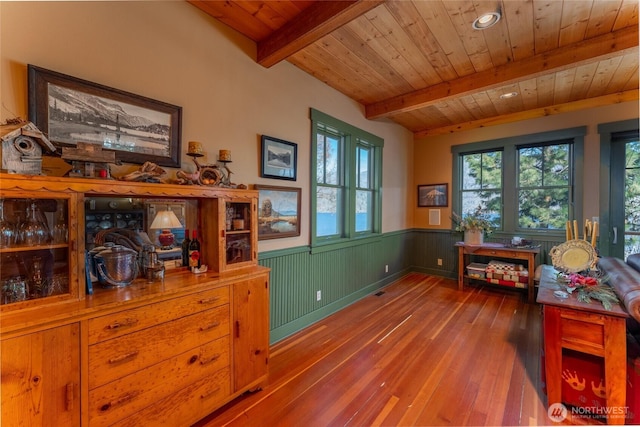 dining area featuring beam ceiling, wainscoting, wooden ceiling, and wood-type flooring