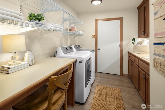 1118 2nd Ave S, Edmonds, WA 98020 - washroom featuring washer and clothes dryer, cabinet space, and light wood-style flooring