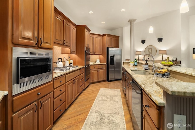 1118 2nd Ave S, Edmonds, WA 98020 - kitchen featuring stainless steel appliances, a sink, brown cabinets, light stone countertops, and hanging light fixtures