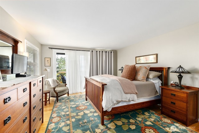bedroom with access to exterior and light wood-style flooring