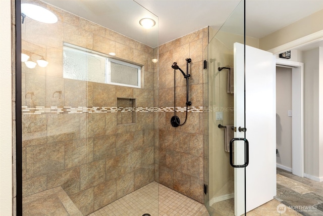 bathroom featuring a shower stall and baseboards
