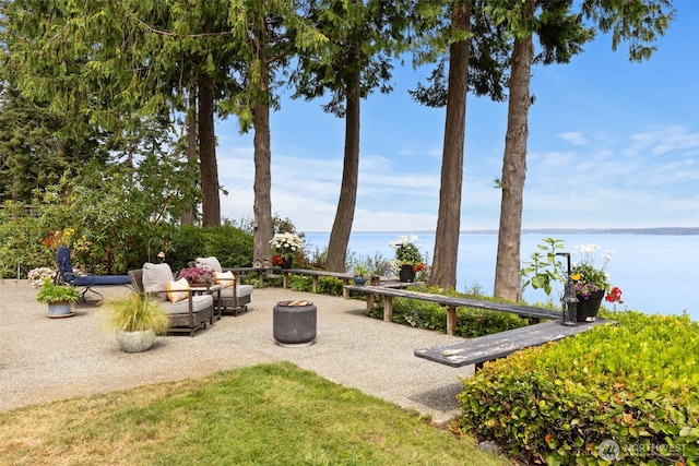 surrounding community featuring a water view, an outdoor fire pit, and a patio