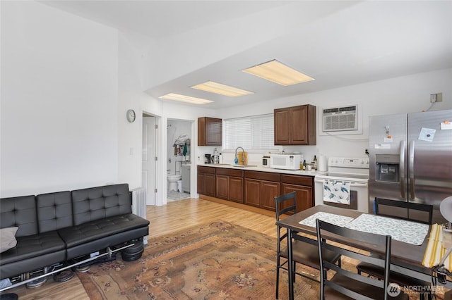 20501 Delta Rd NW, Soap Lake, WA 98851 - kitchen with white appliances, a wall mounted AC, light wood finished floors, a sink, and light countertops