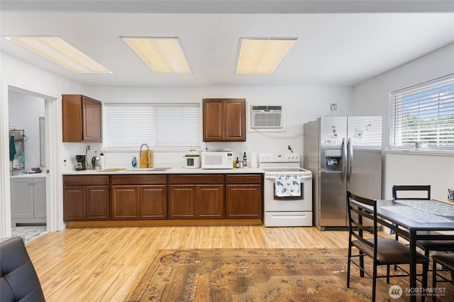 20501 Delta Rd NW, Soap Lake, WA 98851 - kitchen with white appliances, a sink, an AC wall unit, and light wood finished floors