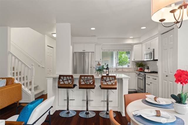 18808 19th Dr SE, Bothell, WA 98012 - kitchen featuring high quality appliances, light countertops, dark wood-type flooring, white cabinetry, and recessed lighting