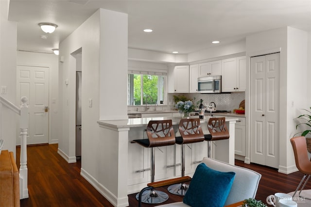 18808 19th Dr SE, Bothell, WA 98012 - kitchen featuring stainless steel microwave, light countertops, white cabinets, decorative backsplash, and recessed lighting