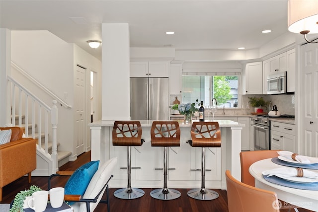 18808 19th Dr SE, Bothell, WA 98012 - kitchen featuring high end appliances, dark wood finished floors, light countertops, a center island, and recessed lighting