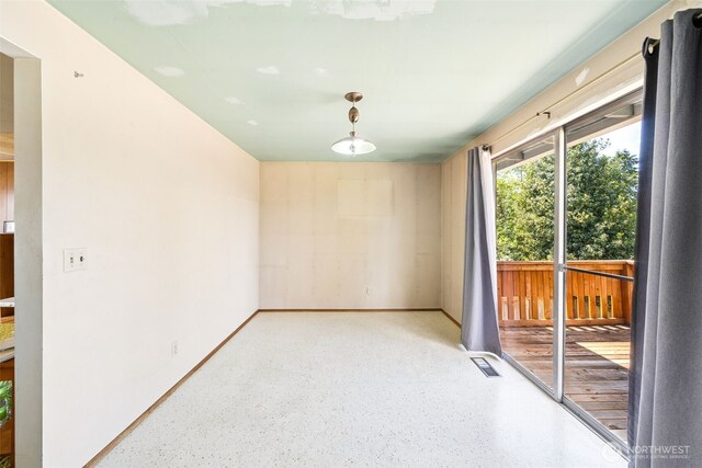 unfurnished room with dark aggregate flooring and baseboards