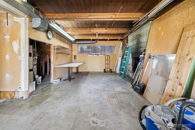 below grade area featuring a garage, wooden ceiling, and water heater