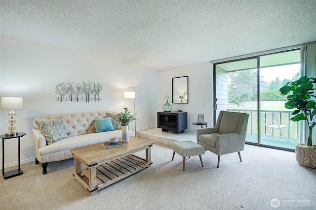 carpeted living room featuring a wood stove, a wall of windows, and a textured ceiling