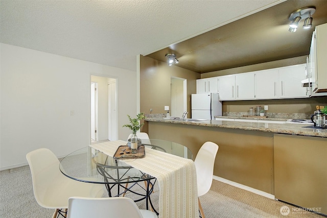 dining room with carpet floors and baseboards