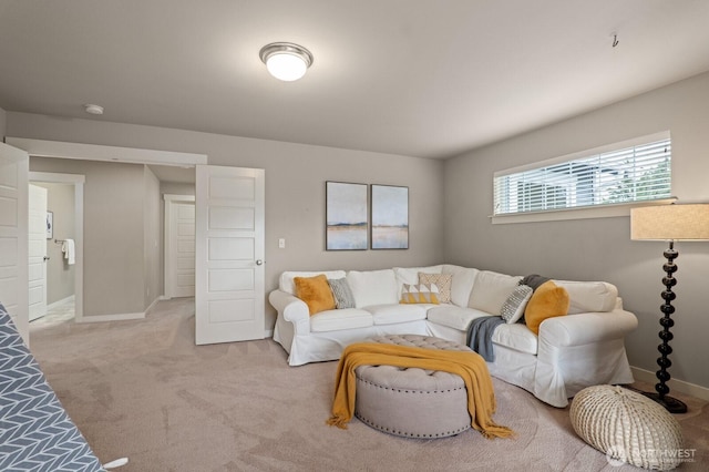 living area featuring light colored carpet and baseboards