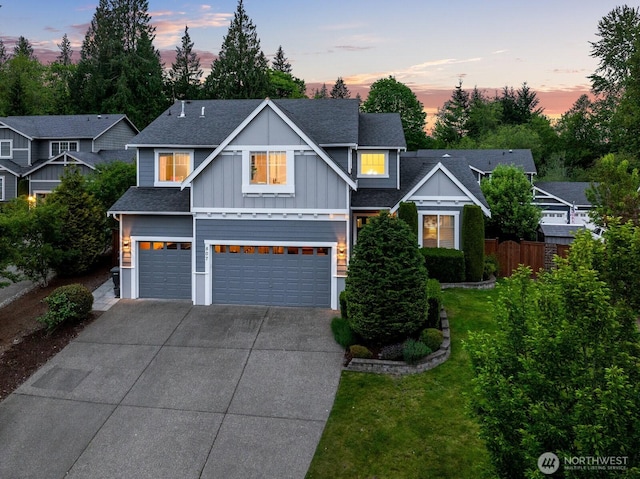 view of front facade with board and batten siding, concrete driveway, a garage, and a shingled roof