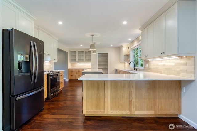 kitchen with stainless steel appliances, a peninsula, backsplash, a sink, and recessed lighting