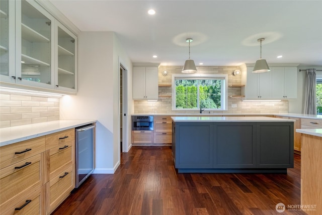 kitchen featuring tasteful backsplash, light countertops, dark wood-type flooring, glass insert cabinets, and recessed lighting