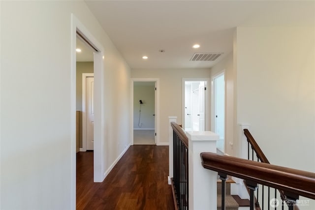 hallway featuring an upstairs landing, dark wood-type flooring, recessed lighting, and baseboards