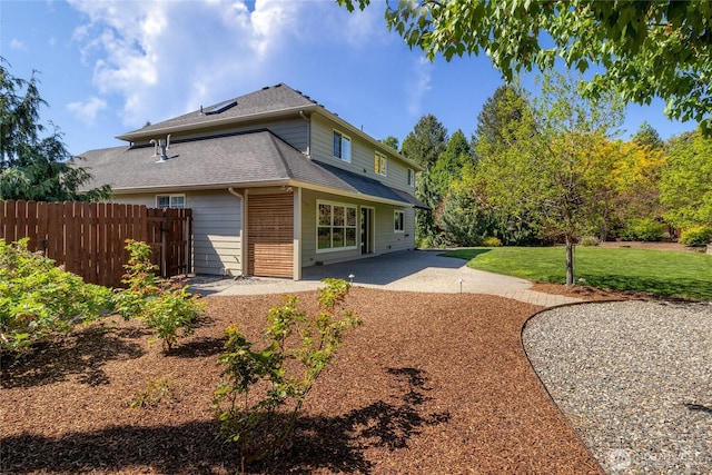 back of house with a patio area and a shingled roof